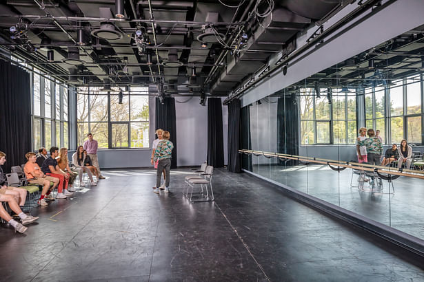 The black box theater serves as a multipurpose space for acting, stagecraft, dance, and yoga classes, as well as for theater and dance rehearsals and performances. The theater can also be used for post-production functions. Finishes are utilitarian; the floors are frequently “chalked up” with stage markings and the mirrors covered with instructions written with glass-safe markers. Catwalks, lighting, and seating are flexible and often reconfigured. Photo credit: Jonathan Hillyer