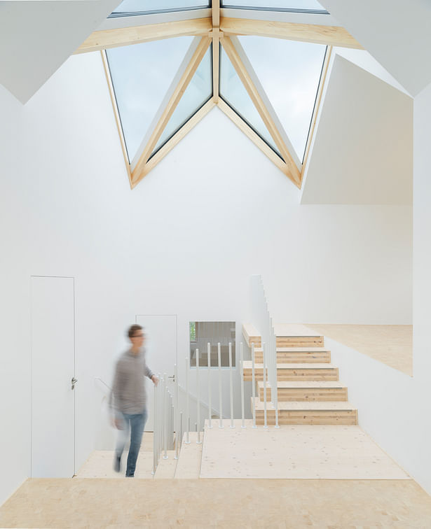 The staircase is flooded with natural light by a large triangulated skylight. (photo: Gui Rebelo / rundzwei Architekten)