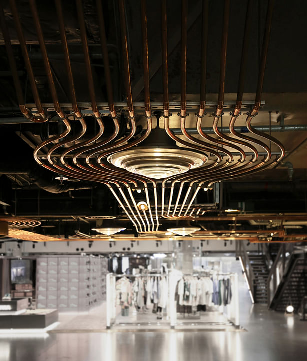 A detail image of the copper conduits running at the ceiling throughout the retail space.