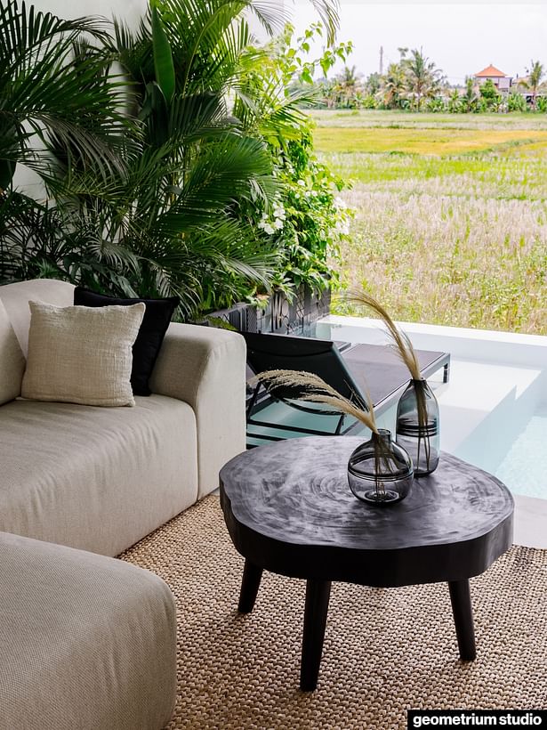 Wooden round table next to the sofa and the pool