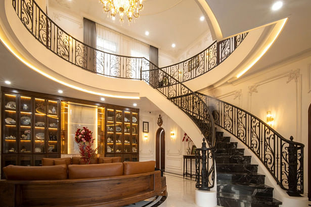 A unique highlight of the house is the circular atrium that extends from the ground floor to the first floor, located in the living room. This design not only leaves a strong impression on visitors but also helps with natural ventilation, creating a cool and airy atmosphere throughout the house.