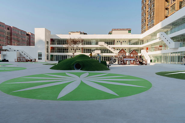 The slides on the building and the hillocks on the playground create happy undulations. © Commune One, Zhang Hetian