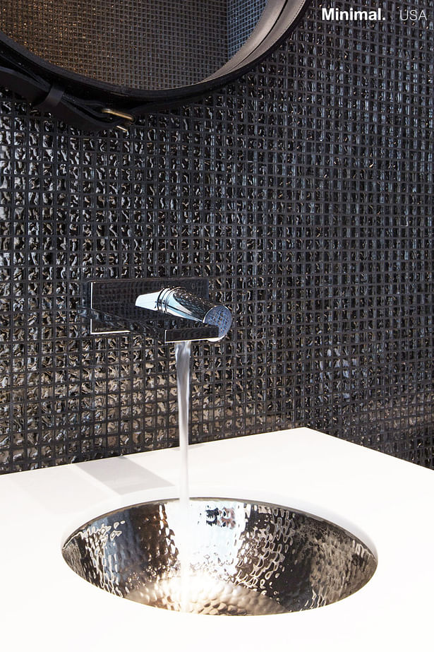 The integrated sink, surrounded by the Corian top, takes up the theme of the mosaic on the wall, keeping the design fluid.