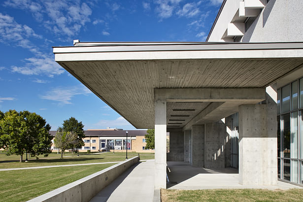New cast-in-place concrete porch at main entrance becomes the campus 