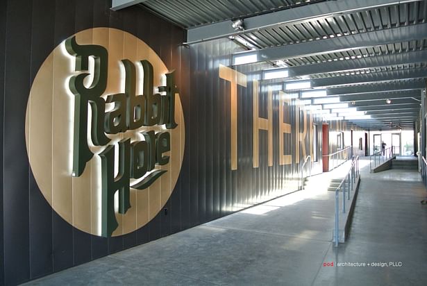 Custom-designed signage, also created by pod architecture + design, welcomes visitors to Rabbit Hole.