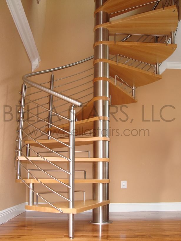 This Spiral Staircase features curved stainless steel rod railings with a top mounted handrail and natural beech wood treads.