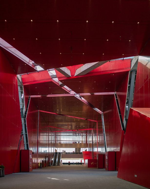 Vivid red corridor with diagonally sliced skylights
