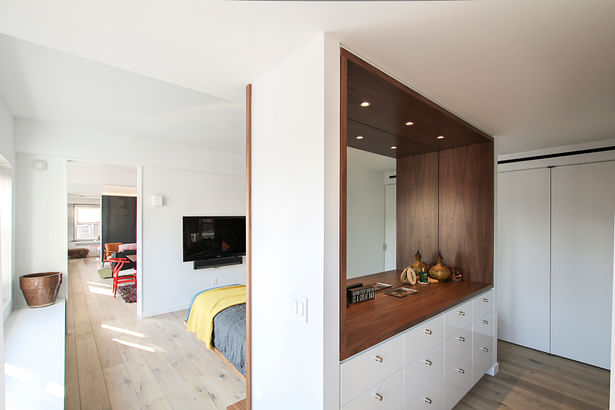 The Backside of the Headboard Wall Includes a Built-In Dresser and Oversized Mirror.
