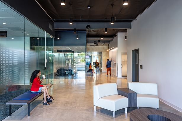 Upon entering, the user can see across the entire building to the exterior patio at the rear. The shifting programmatic volumes along the corridor provide a distinct series of spaces where the employees can pause to engage each other.