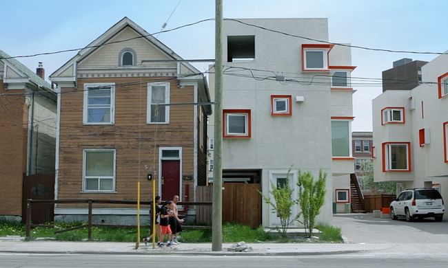 Surreal quality ... Centre Village, right, with Winnipeg’s more typical wood-framed gabled houses, left - Photograph In Contex