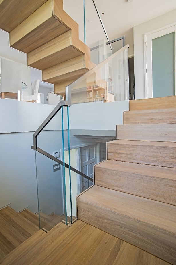 White Oak Treads and Risers, with StarFire Glass Railings give this three story town-home a bright and beachy feel.