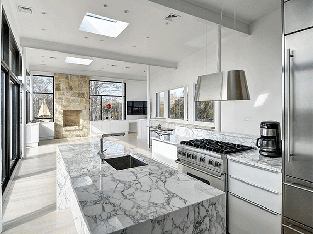 Stunning white marble countertops and modern fixtures give the open concept kitchen a clean, crisp finish.