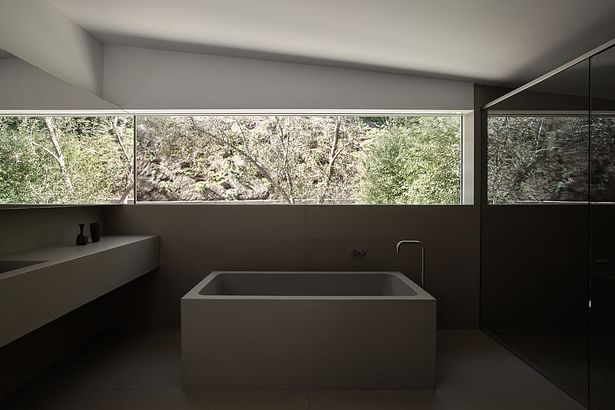 'A custom concrete tub and vanity in the master bathroom was inspired by one of the client's favorite architects, John Pawson, who designed something similar in his Baron House. A room-width window illuminates the space, enhanced by mirrors on both sides.'