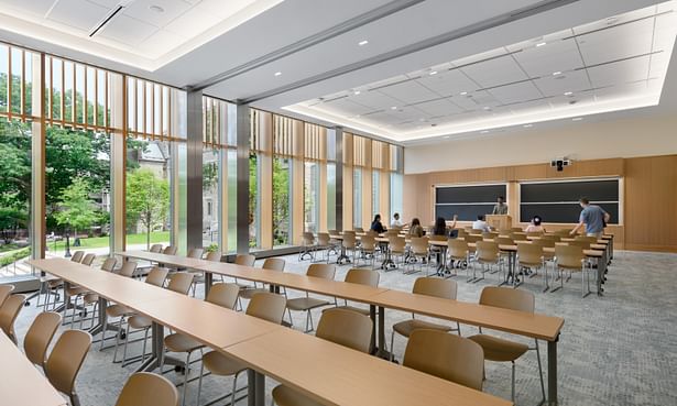 The multipurpose room on the second floor of the new addition accommodates an audience of 200, allowing the school to host large events, conferences, and colloquia that could not be accommodated in the existing building. The daylit space with state-of-the-art, integrated audio-visual technology can be quickly reconfigured for less formal events and gatherings. A movable wall allows the space to be divided into two smaller classrooms. Image credit: Chuck Choi.