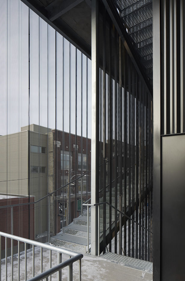 Cantilevered open-air stairs clad with a fine grain metal mesh offer unexpected views of the surroundings.