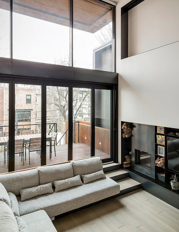 Wall of Folding Glass Doors Opens Living Space to Dining Terrace and Backyard