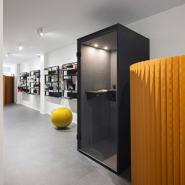 Acoustic booth overlooking modular desks/office library Photo: Ivo Tavares