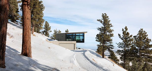 The house is composed of economical, fire resistant materials. The closely spaced horizontal guardrail on the deck visually disappears and keeps the focus on the simple forms.