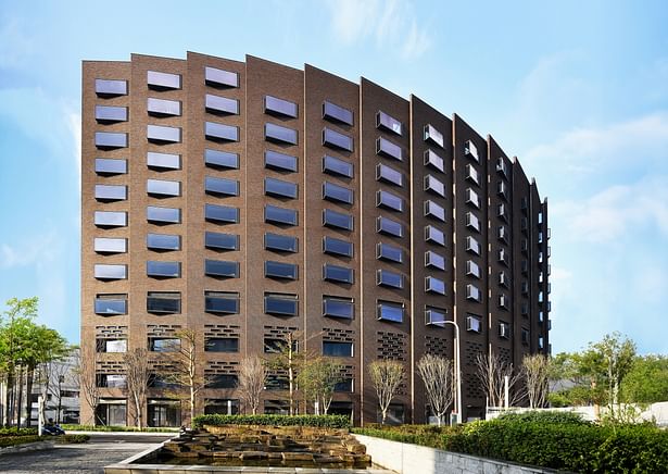 Successive brick bays form the curved wall of the spiral building