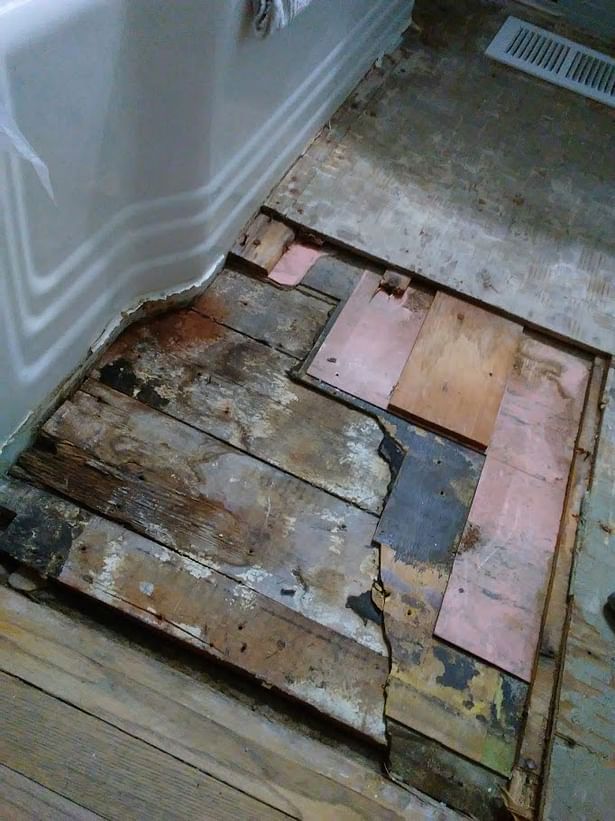 Removal of the 'wobbly' floor revealed many years' worth of shims & incompatible materials (probably installed in an attempt to 'level' the floor for tiling). All these materials were removed & replaced with a self-leveling lightweight slab. 