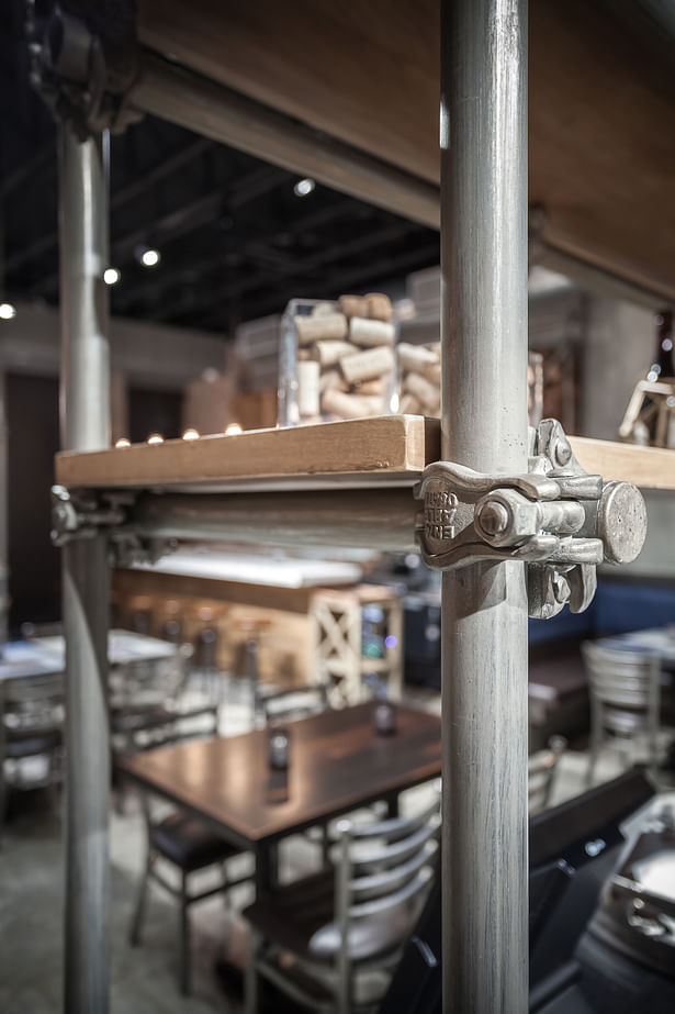 The nostalgic effect of these scaffolds, along with the careful treatment of details, such as the pipe fittings, rough sawn shelving and artful lighting, help manifest the brand identity spatially.