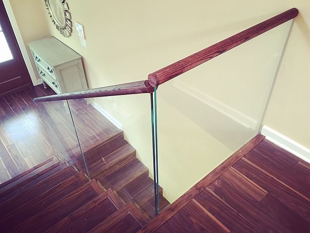 Glass railings were top mounted with a Wooden cap rail, stained to match the treads.