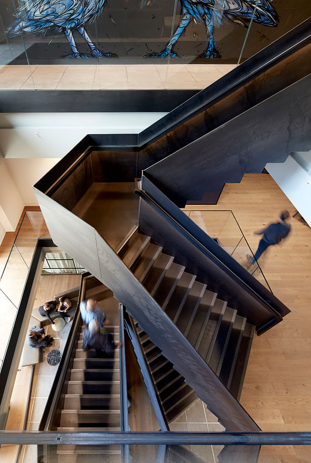 The patinated steel staircase drives interactions between staff and visitors