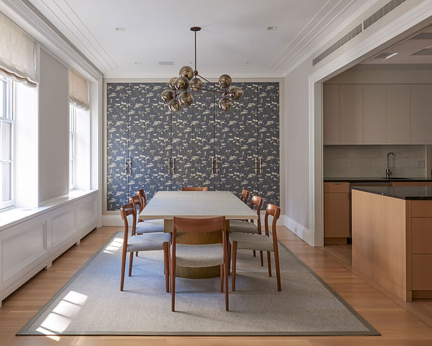 Dining room with custom wallpaper that conceals additional storage.