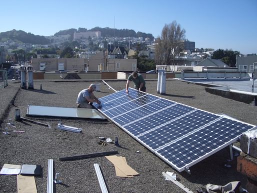 Workers installing solar cells on an existing home. Image courtesy of Flickr user brian kusler.