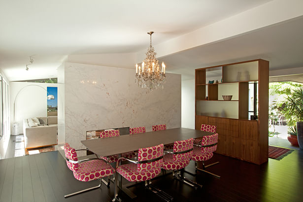 The new dining area framed by the dolomite-class fireplace, and a walnut and glass display case that creates the entry area, yet still allows light into the house.