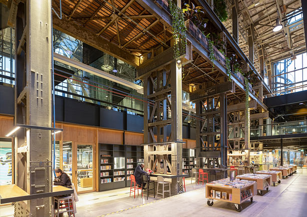 In this book street, books are also checked in and out. The bookcase wall on the office side has transparent display cases for works of art and unique books. This wall also gives staff the right balance between privacy and connection with the library.