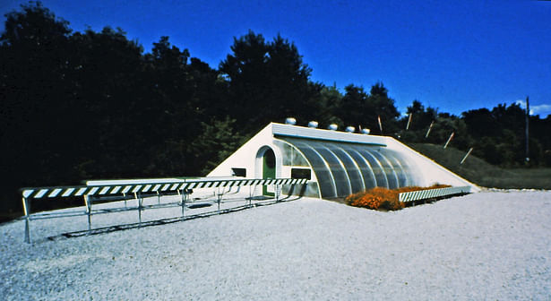 Commercial greenhouse built in 1980. The plants could be moved on a large mobile platform in and out of a underground tunnel from day to night in order to keep the plants warm during the winter without supplemental heat.