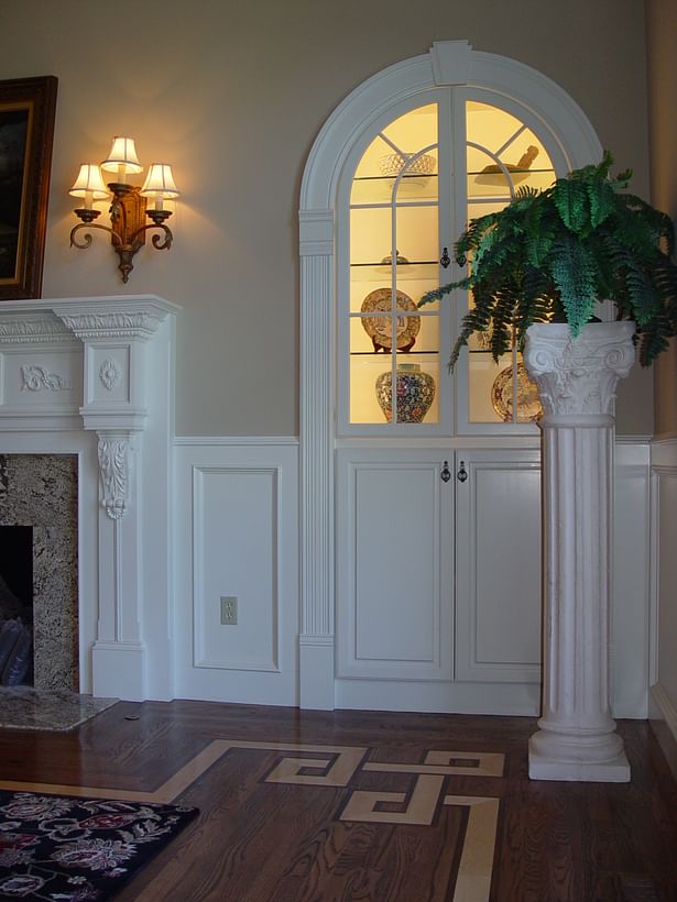 Detailed fireplace surround with wainscoting detail and custom arched built-in