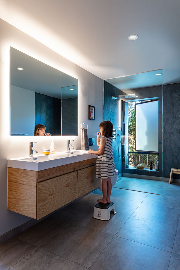 The master bathroom flows seamlessly into the shower and to the exterior via a large window.