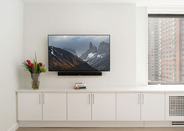 On this gut renovation we created aditional storage by hiding the radiator cover under thw window and creating a space for the TV