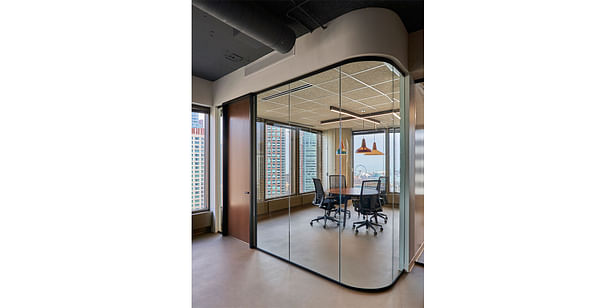Small meeting room enclosed with curved glass. 