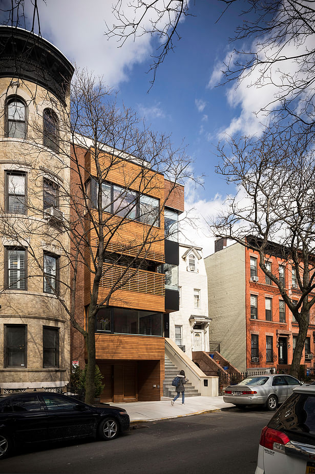 Street Elevation Responds to Context by Aligning with Cornice of Neighboring Townhouses
