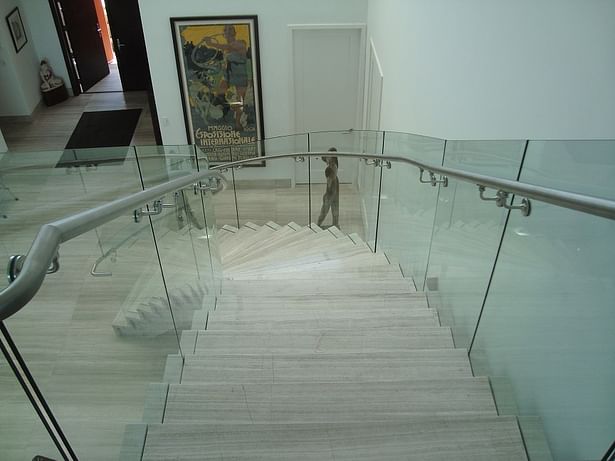 Curved glass railings with a stainless steel handrail directly mounted to the glass railings.