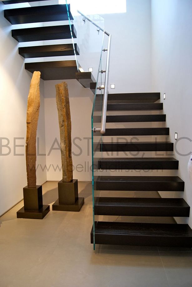 Floating staircase featuring wood treads with open risers and glass railings