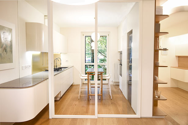 kitchen separated by living room, a glass makes between the kitchen and the living room connects the two spaces 