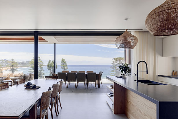 Open plan kitchen and dining area with seamless connection to balcony