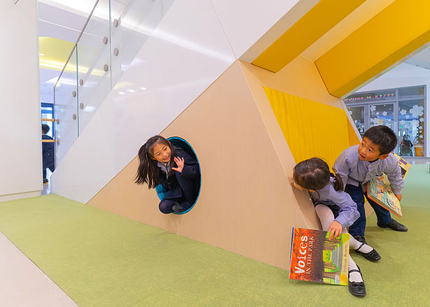 Young students experience surprise and delight playing in the 'nest' space under stairs 