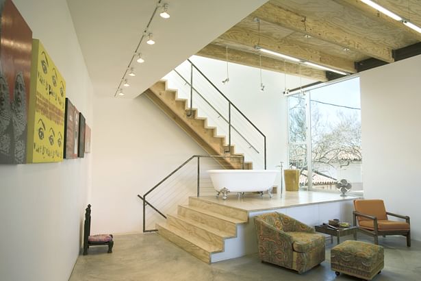 Interior view of the studio showing the stair access to the roof deck and featuring a functioning bathtub on the landing.
