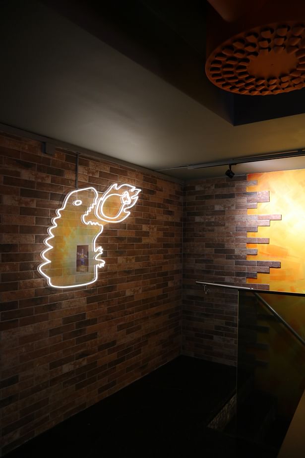 Second floor: Monster-shaped lighting is pointed on the brick wall
