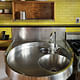 Her custom stainless steel kitchen sink, which is inset with a mixing bowl and bucket. Annie Schlechter