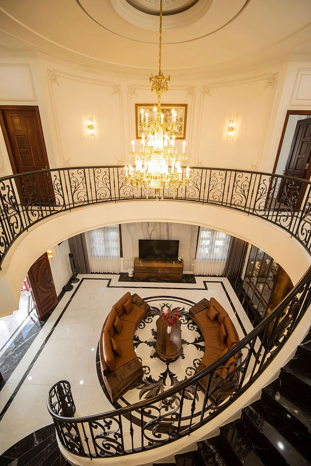 A unique highlight of the house is the circular atrium that extends from the ground floor to the first floor, located in the living room. This design not only leaves a strong impression on visitors but also helps with natural ventilation, creating a cool and airy atmosphere throughout the house.