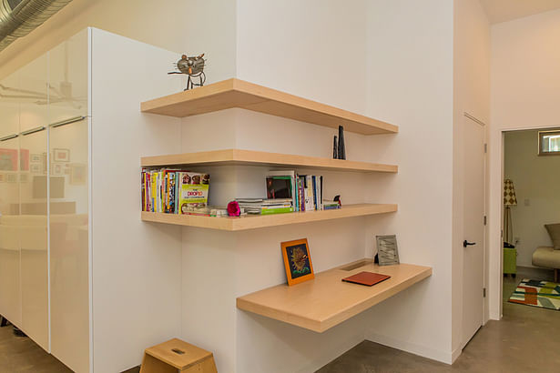 Custom corner shelving becomes a “charging station” for the owners’ devices.