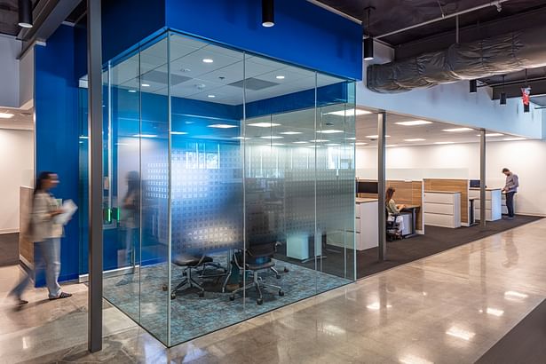 The huddle rooms have three sides of obscured glass to allow the activity within to activate the office, while still providing privacy to the adjacent workstations.