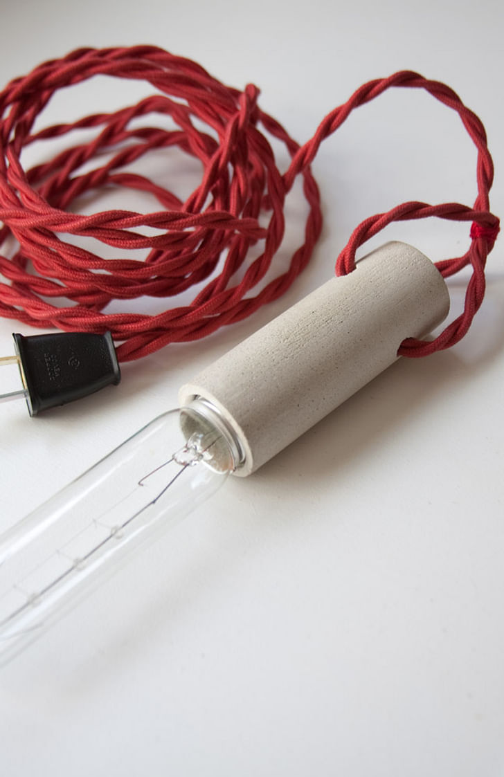 cylinder series – pendant : cast concrete socket with fabric covered wires and T10 light bulb.