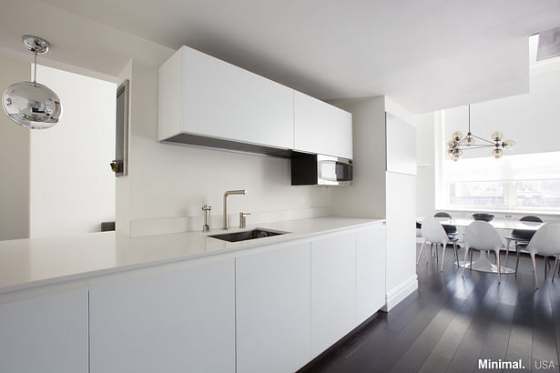 The design choice of the white countertop, not only lights up the small space, but also makes the kitchen sleek and clean while the upper cabinets complete the storage system with which the kitchen is equipped.